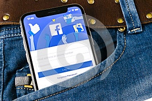 Facebook application icon on Apple iPhone X smartphone screen close-up in jeans pocket. Facebook app icon. Social media icon. Soci