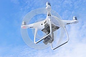 The New Aircraft DJI Phantom 4 pro quadcopter drone with 4K video camera and wireless remote controller flying in the sky. Aerial