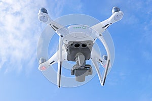 The New Aircraft DJI Phantom 4 pro quadcopter drone with 4K video camera and wireless remote controller flying in the sky. Aerial