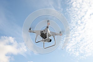 The New Aircraft DJI Phantom 4 pro quadcopter drone with 4K video camera and wireless remote controller flying in the sky. Aerial