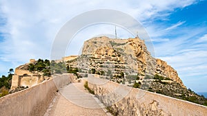 Santa Barbara Castle and pathway on fortification wall on Benacantil hill in Alicante, Spain. Neighborhood El Barrio or photo