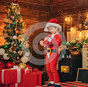 Santa boy little child celebrate christmas at home. Family holiday. Boy cute child cheerful mood play near christmas