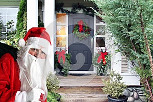Santa bringing Christmas presents to a decorated home.
