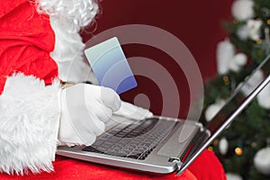 Santa buying by plastic card Christmas gift in Internet