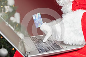 Santa buying by plastic card Christmas gift in Internet