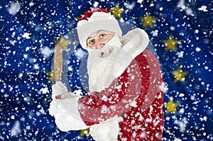 Santa Claus aggressively threatens with a bat against the backdrop of falling snow and the flag of European union