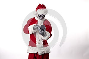 Santa Claus with alien mask wearing a smart phone on a white background