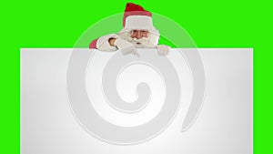 Santa Claus appears behind a white sheet with space for tex, Green Screen, stock footage