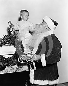 Santa Claus with baby on mantle