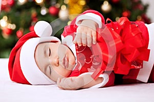 Santa claus baby sleeping and holding present