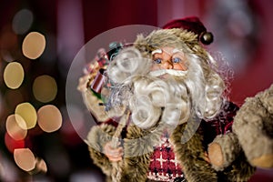 Santa Claus on the background of the Christmas or New Year tree, which leaves in bokeh.