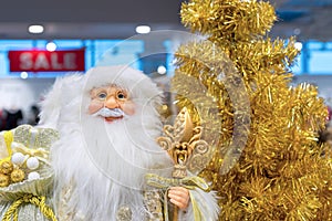 Santa Claus with bag of gifts on the background of a golden Christmas tree.