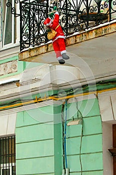 Santa Claus with a bag on his back, up the rope ladder