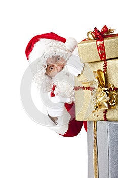 Santa Claus behind Christmas gift boxes