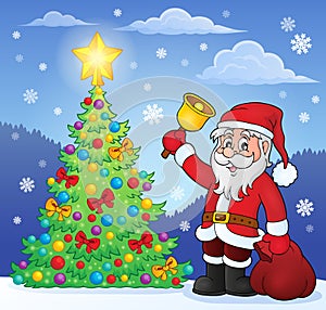 Santa Claus with bell by Christmas tree