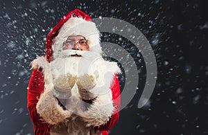 Santa Claus blowing magic snow of his hands