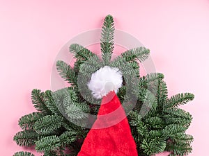 Santa claus cap detail on spruce branch on pink
