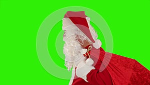 Santa Claus carrying his bag, looks at the camera and winks, Green Screen, stock footage