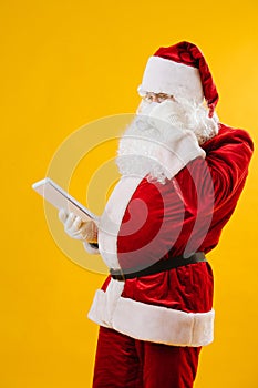 Santa Claus checking his order list while drinking hot coffee.