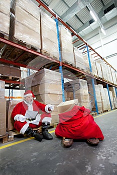 Santa claus checking list of gifts in storehouse photo