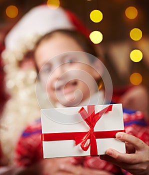 Santa Claus and child girl posing together indoor near decorated xmas tree with lights, they talking and smiling - Merry Christmas