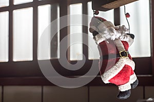 Santa Claus, Christmas concept with Santa Claus climbing a rope, Copy space to the left and window in the background