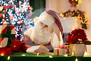 Santa Claus on Christmas eve. Presents under tree