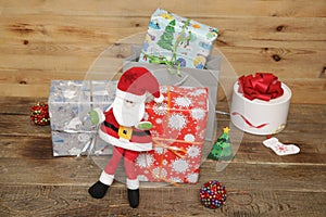 Santa Claus with Christmas gifts and gift box on a wooden background. Christmas and New year concept.