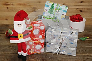 Santa Claus with Christmas gifts and gift box on a wooden background with copy space for text. Christmas and New year concept.