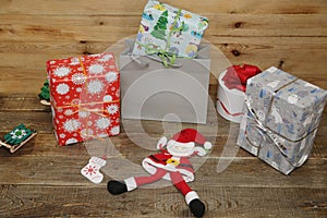Santa Claus with Christmas gifts and gift box on a wooden background with copy space for text. Christmas and New year concept.
