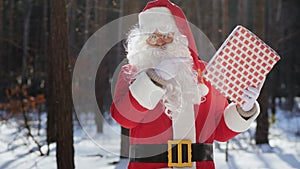 Santa Claus with Christmas present in hand in the park