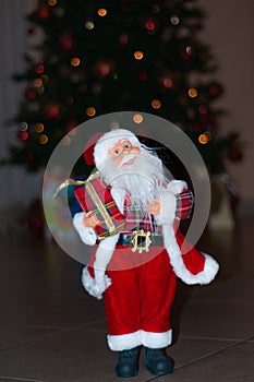 Santa Claus at Christmas time, with a Christmas tree behind