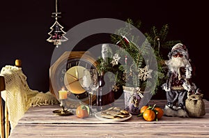 The Santa Claus, clock, tangerines, christmas cookies and champagne