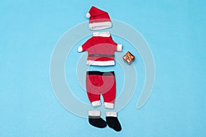 Santa Claus clothes and little red present on blue background