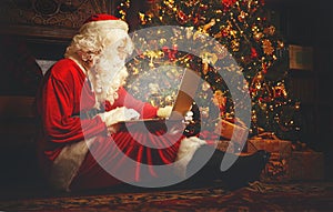 Santa Claus with computer before christmas