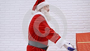 Santa Claus in costume singing and pushing shopping trolley