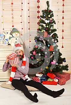 Santa Claus with curious face on bureau and Christmas tree