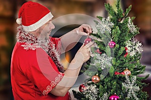 Santa Claus decorating Christmas tree with balls
