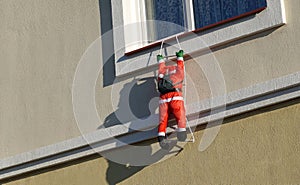 Santa Claus doll adorns the facade of the house. Christmas Decoration