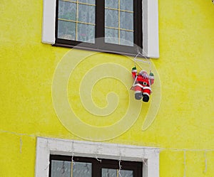 Santa Claus doll adorns the facade of the house. Christmas Decoration