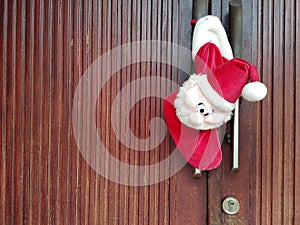 Santa claus doll hanging on the front door of the house