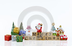 Santa Claus doll on merry christmas wooden word with gifts decoration on white background