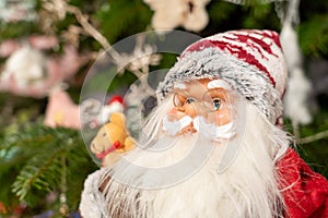 Santa claus doll portrait, christmas tree at background