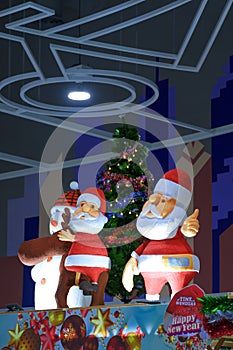 Santa Claus dolls and Christmas decorations with lighting display inside of department store during Christmas festival