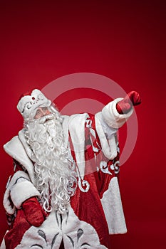 Santa Claus in facny costume pointing away with arm.