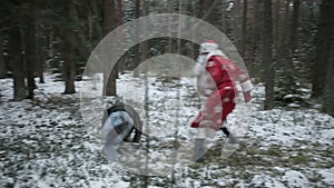 Santa Claus is fighting in the woods with robbers. Slow motion