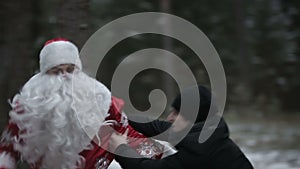 Santa Claus is fighting in the woods with robbers. Slow motion