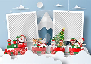 Santa Claus and friend on Xmas train at the snow mountain with blank photo frame
