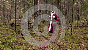 Santa Claus with gift bag walking through the forest
