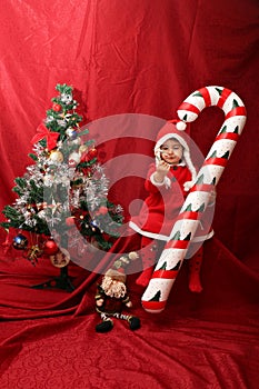 The Santa Claus girl, the oversized candy cane and the Christmas tree